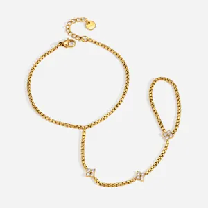 Bracelet de main en acier doré avec breloques trèfle en zircon, vue détaillée produit.