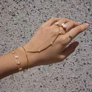 Élégant bracelet de main et ensemble de bagues en acier doré avec fleurs en zircon