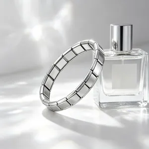 Gros plan d'un bracelet modulaire en acier inoxydable argenté avec flacon de parfum