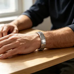 Détail d'un bracelet modulaire en acier inoxydable argenté sur le poignet d'un homme