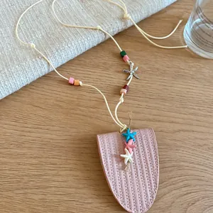 Detailed view of pink leather pendant necklace with colorful beads and cute starfish charms.