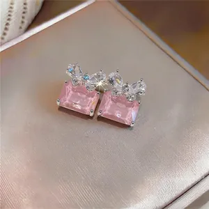 Close-up of elegant pink rectangular zircon stud earrings with sparkling butterfly detail