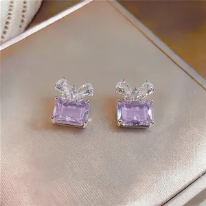 Close-up of elegant purple zircon stud earrings with a sparkling bowknot design