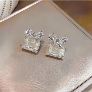 Detailed close-up of elegant butterfly zircon earrings with rectangular crystals.