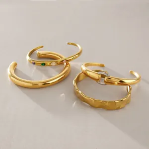 Vista dettagliata di quattro bracciali a polsino aperti in acciaio inossidabile dorato, set 4
