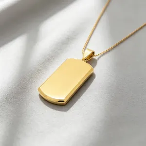 Polished gold dog tag pendant showing blank engravable surface and fine chain detail.