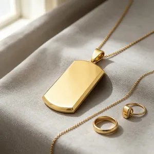 Detailed view of polished gold titanium steel dog tag pendant and rings on soft textured fabric