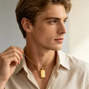 Close-up of a blank gold-toned titanium steel dog tag necklace worn by a male model.