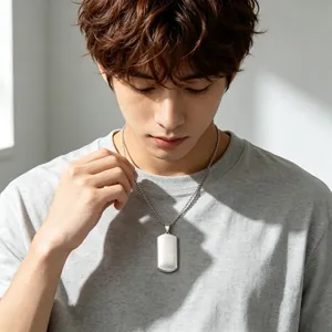 Close-up detail of a minimalist blank titanium steel dog tag pendant on a male model.