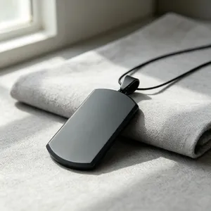 Close-up macro view of minimalist matte black titanium steel dog tag pendant necklace