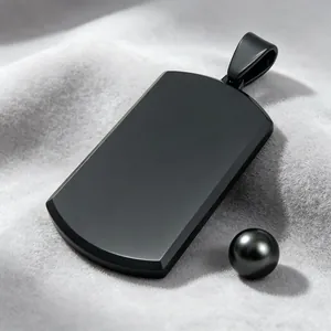Detailed macro view of a sleek matte black stainless steel dog tag pendant on grey velvet