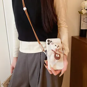 Close-up of cute plush bear pendant with brown braided crossbody phone strap accessory