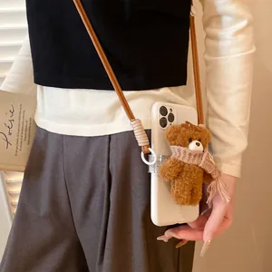 Cute brown plush bear phone charm with a pink scarf and a brown woven cross-body strap.