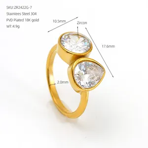 Detalle de anillo asimétrico bañado en oro de 18 quilates con circonitas redondas y de pera.