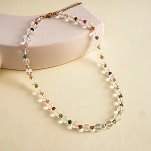 Detailed view of colorful beaded necklace featuring clear glass beads and gold clasp.