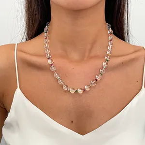Close-up detail of a clear glass bead necklace with colorful accents worn by a model