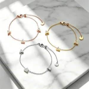 Detailansicht von drei minimalistischen Titanstahl-Armbändern mit Dreieck-Anhängern.