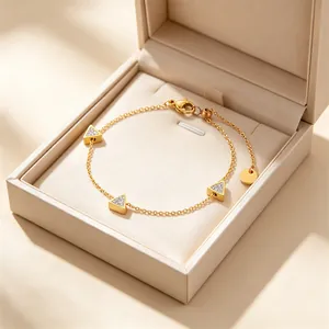 Detailansicht eines goldenen Armbands mit geometrischen Dreiecken in einer Schmuckbox.