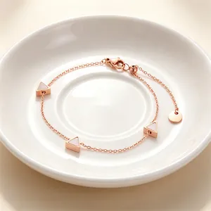 Detailansicht eines verstellbaren roségoldenen Titanstahl-Armbands mit Dreieck-Muschel-Inlays.