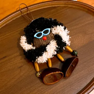 Vue détaillée d'un charmant pendentif de poupée en peluche et bois fait main