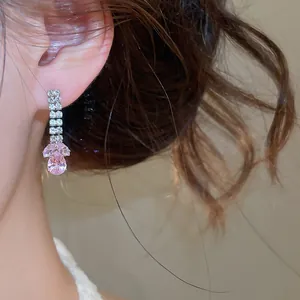 Detailopname van een elegante roze zirkoon waterdruppel hanger oorbel op het oor