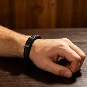 Zwarte gevlochten lederen armband met matzwarte magnetische sluiting om de pols