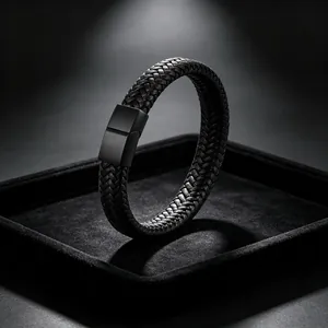 Detailopname zwarte gevlochten leren armband met matte magnetische sluiting op dienblad