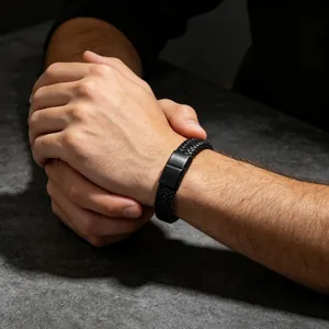 Detailopname van een herenarmband van gevlochten zwart leer met magneetsluiting