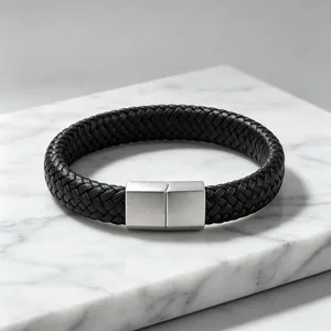 Detailopname van zwarte gevlochten leren armband met mat titaanstaal sluiting