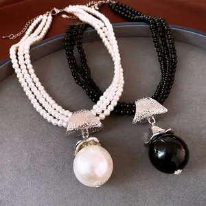 Élégant collier de perles multicouche avec grand pendentif perle et accents argentés
