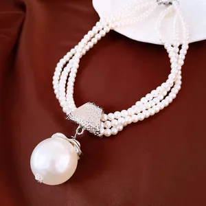 Gros plan d'un élégant collier de perles multicouches avec un grand pendentif détaillé