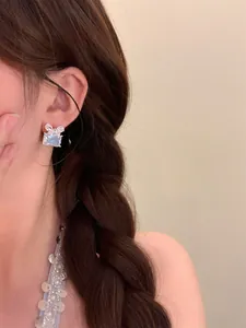 Gros plan sur des boucles d'oreilles en zircon carré avec détail de nœud élégant
