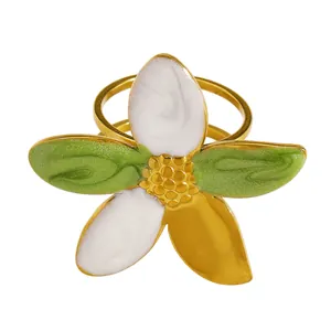 Detail view of a vintage gold flower ring with green and white enamel petals