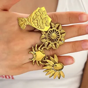 Detailed view of vintage gold stainless steel flower and crab open rings on hand.