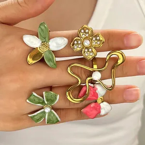 Macro view of vintage colorful enamel flower and bow rings worn on female fingers