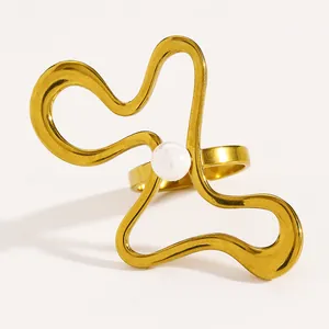 Detail view of the irregular wavy gold-tone stainless steel ring with center pearl.