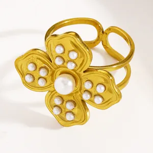 Close-up of gold stainless steel flower ring with white pearl details.