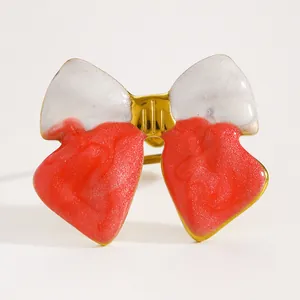 Detailed view of red and white glittery enamel bow-knot open ring in gold finish