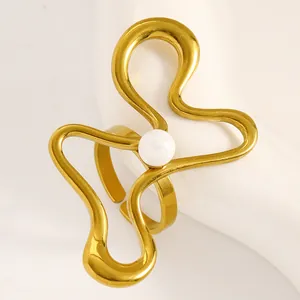 Detailed shot of unique gold wavy open ring featuring a central white pearl-like bead.