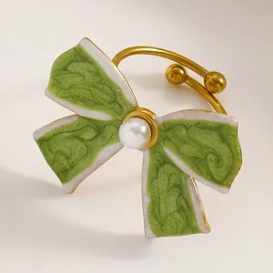 Macro detail of a vintage green enamel bow ring with pearl on adjustable band