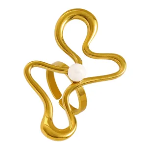 Detailed view of a gold wavy stainless steel ring with a central white pearl accent