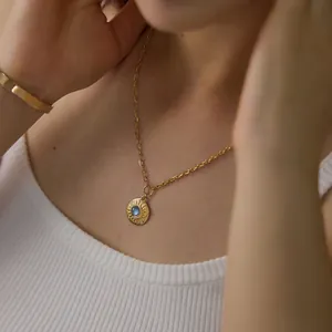 Nahaufnahme der goldenen Sonnenanhänger-Halskette mit blauem Stein und feinen Glitzersteinen