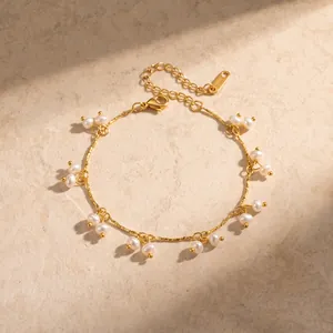 Detailed macro view of elegant gold chain bracelet adorned with small white pearls
