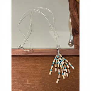 Close-up detail of Bohemian beaded tassel necklace with turquoise and pearl accents.