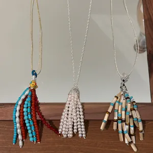 Detail view of three bohemian beaded tassel necklaces in varied vintage styles