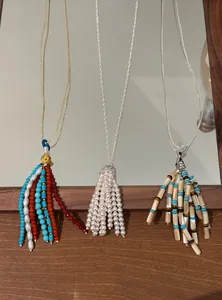 Detail showing three bohemian necklaces with varied bead and pearl tassel pendants