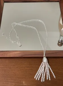 Detailed view of bohemian tassel necklace featuring delicate white pearls and silver chain