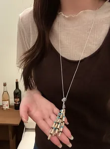 Detailed view of a Bohemian beaded tassel necklace worn over a brown tank top