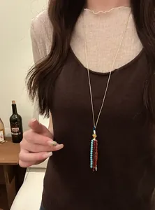 Bohemian beaded tassel long necklace styled on a model wearing a brown knit vest