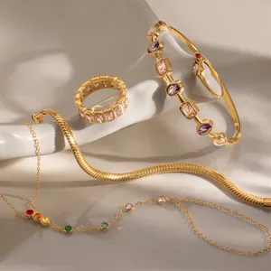 Vista macro de un juego de joyas de acero chapado en oro de 18k con piedras de circón de colores